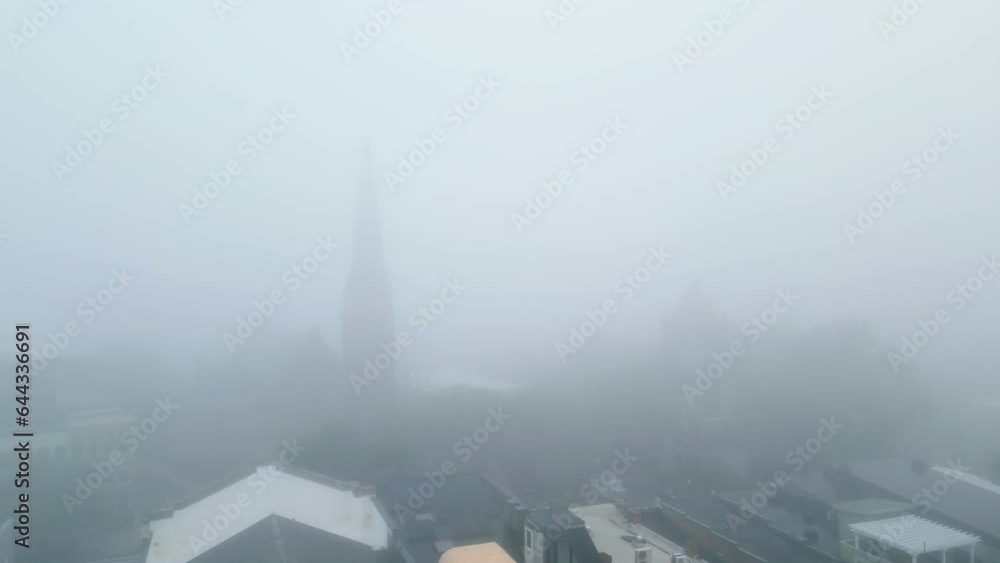 Aerial pan tilt down across foggy downtown building scene, thick white mist Aerial pan tilt down across foggy downtown building scene, thick white mist