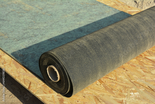 Foto Unrolling waterproofing, water-resistant felt, bituminous roofing underlayment o