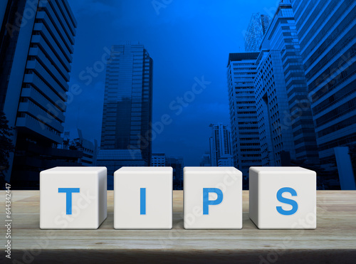 TIPS letter on white block cubes on wooden table over modern office city tower and skyscraper, Business customer service and support concept