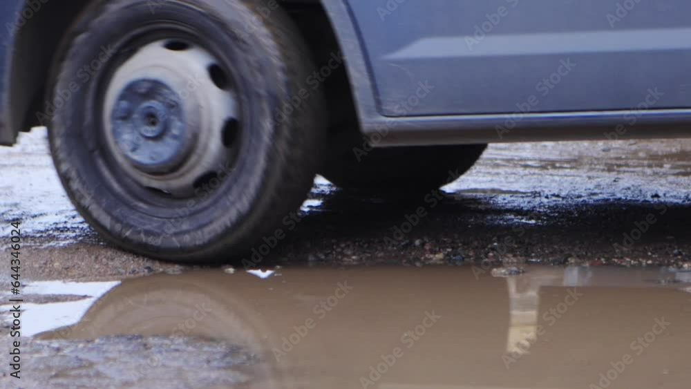 The car is driving on a bad road with puddles, holes and mud. Close-up, suspension car The car is driving on a bad road with puddles, holes and mud. Close-up, suspension car