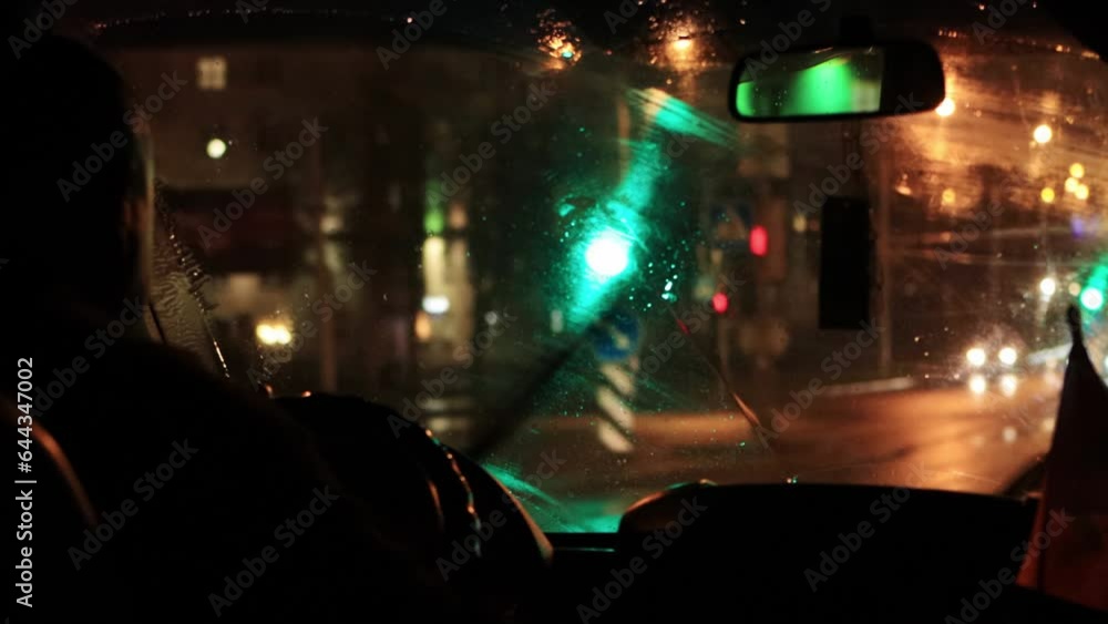 View from the interior of the car windshield at night. Rainy weather, poor visibility, windshield wipers cleaning the glass. Lights from headlights in the city. Copy space for text View from the interior of the car windshield at night. Rainy weather, poor visibility, windshield wipers cleaning the glass. Lights from headlights in the city. Copy space for text