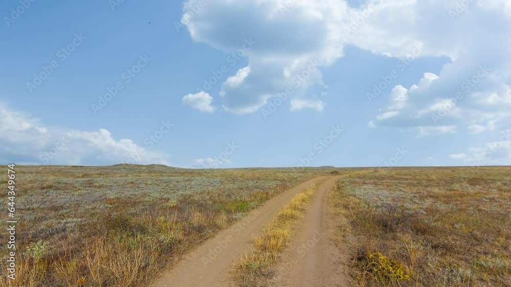 ground road among dry prairie under cloudy sky time lapse scene ground road among dry prairie under cloudy sky time lapse scene