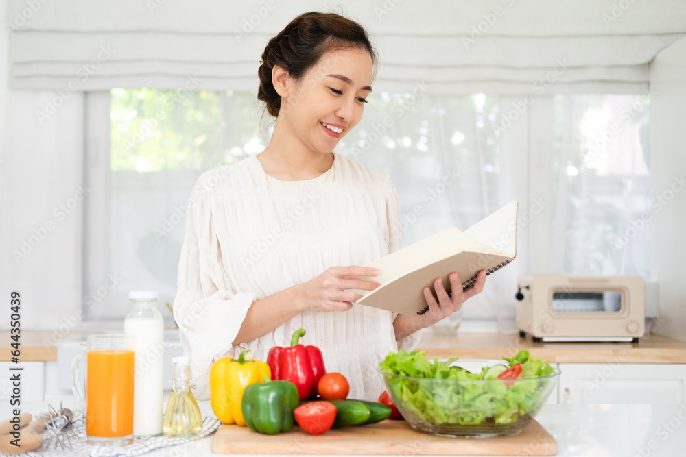 Woman reading recipe for simple summer salad in cookbook. Simple healthy food concept Woman reading recipe for simple summer salad in cookbook. Simple healthy food concept