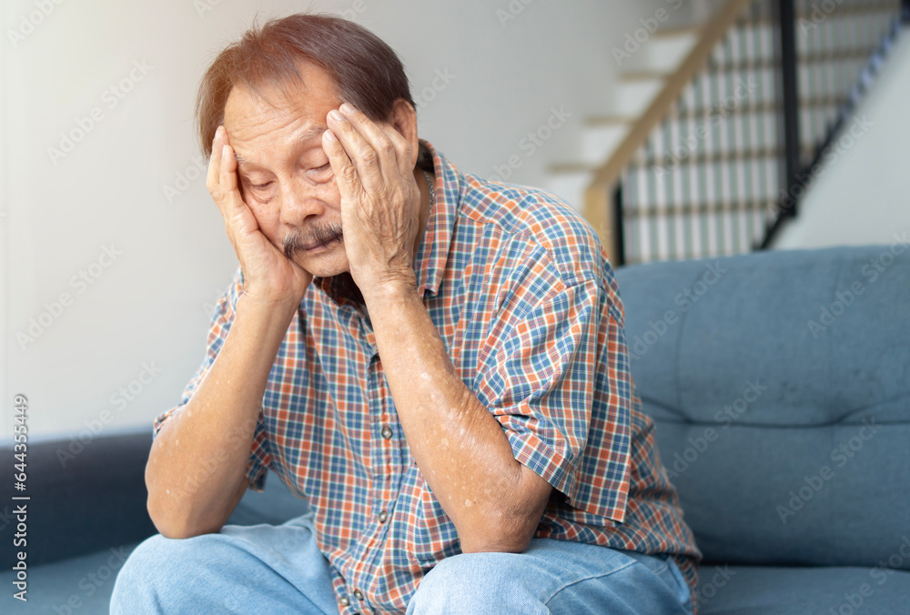 Photo of unhappy upset retired Asian man wear plaid shirt arms head having headache Photo of unhappy upset retired Asian man wear plaid shirt arms head having headache