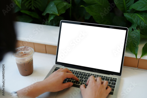 A person working on a laptop in concept business work front view of blank white screen laptop computer with a cup of coffee.