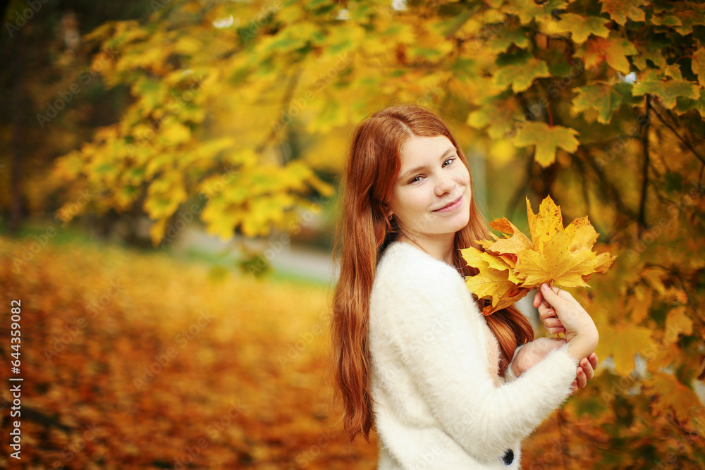 Autumn leaves falling on happy young girl in forest. The colors and mood of autumn. Autumn leaves falling on happy young girl in forest. The colors and mood of autumn.