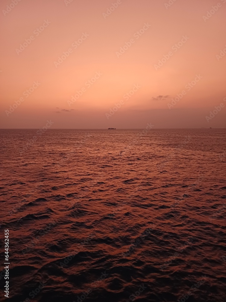 Violet Sunrise on The Sea with A Ship on Horizon