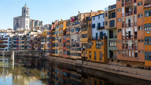 Pintoresque and colourfoul houses by the river with the church in the back in Girona © Ignacio