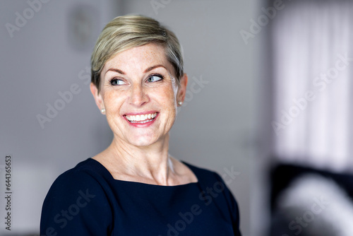 Happy mature woman with short blond hair at home photo
