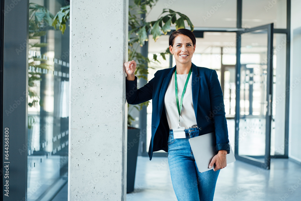 Smiling businesswoman leaning on column in corridor Smiling businesswoman leaning on column in corridor