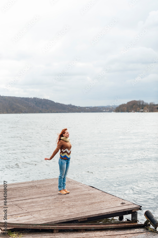 Carefree woman standing on pier by lake Carefree woman standing on pier by lake