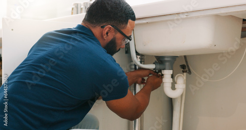 Plumber black man, kitchen and sink maintenance with tools, focus and pipe repair for drainage in home. Entrepreneur handyman, plumbing expert or small business owner in house for fixing water system