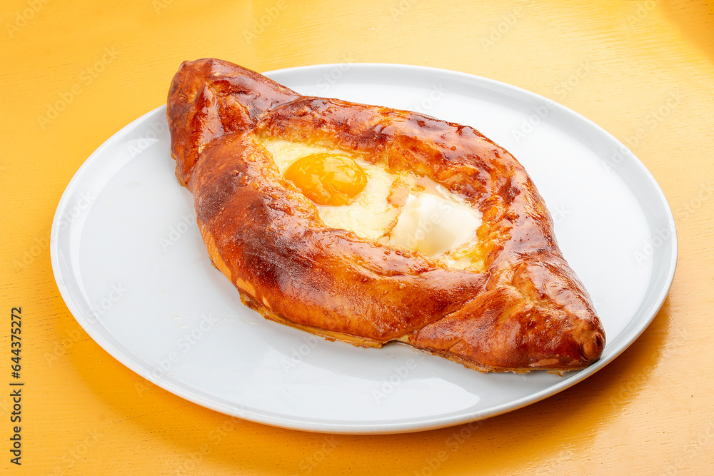 Adjar-style khachapuri with cheese, egg and butter. Caucasian cuisine. Isolated image on a gray background. Adjar-style khachapuri with cheese, egg and butter. Caucasian cuisine. Isolated image on a gray background.