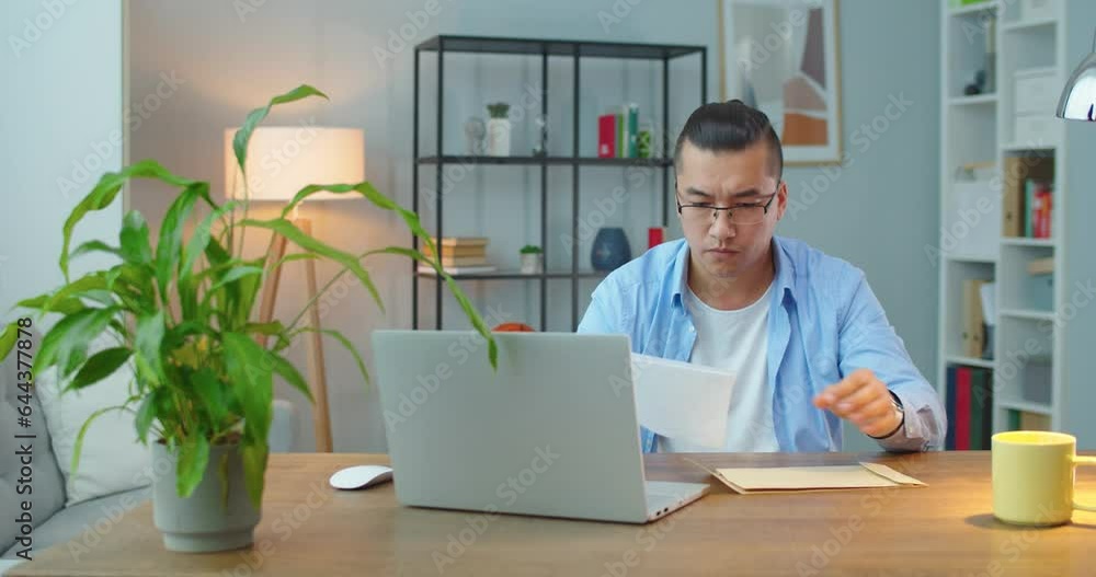 Young asian man open envelope holding paper mail letter reading good news feel excited overjoyed winner got job contract, smiling entrepreneur receive salary taxes refund offer in document Young asian man open envelope holding paper mail letter reading good news feel excited overjoyed winner got job contract, smiling entrepreneur receive salary taxes refund offer in document