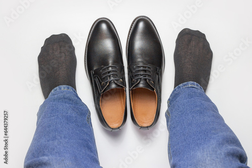 Man in jeans and male shoe on white background top view