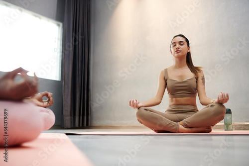 Young woman breathing calmly when meditating in lotus position