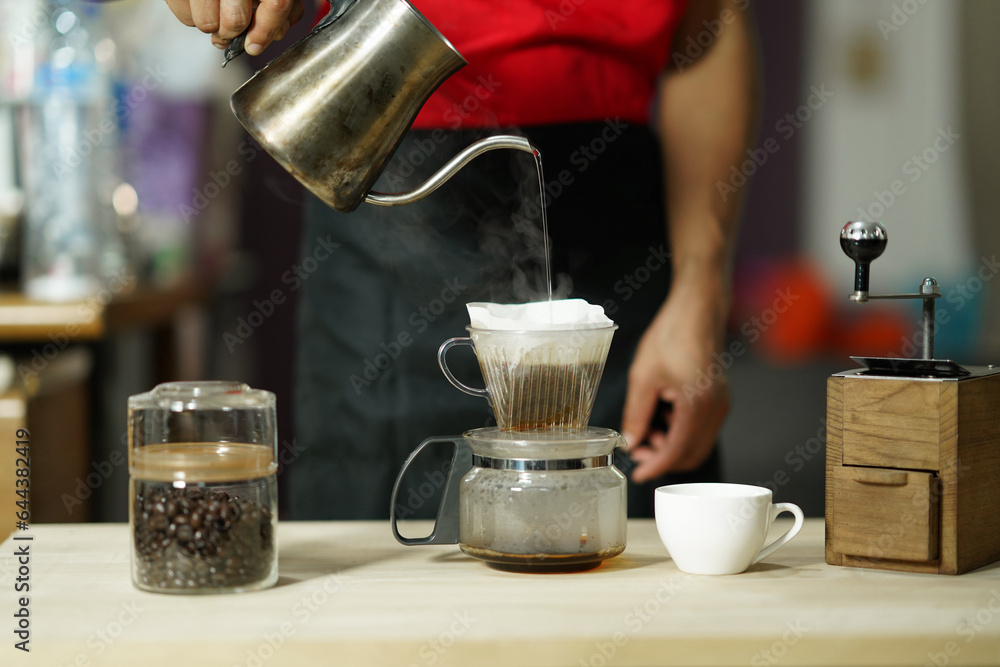 Brewing coffee pouring hot water over roasted ground coffee beans enclosed in a filter, Manual drip method easy to make pour over coffee at home, Coffee drip