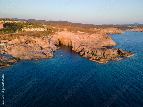 View from a drone at sunset on a bay with blue water. Cala Grotta, Sardinia Italy