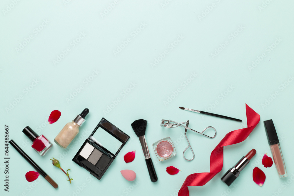 Flat lay with makeup products and tools with flowers on color background Flat lay with makeup products and tools with flowers on color background