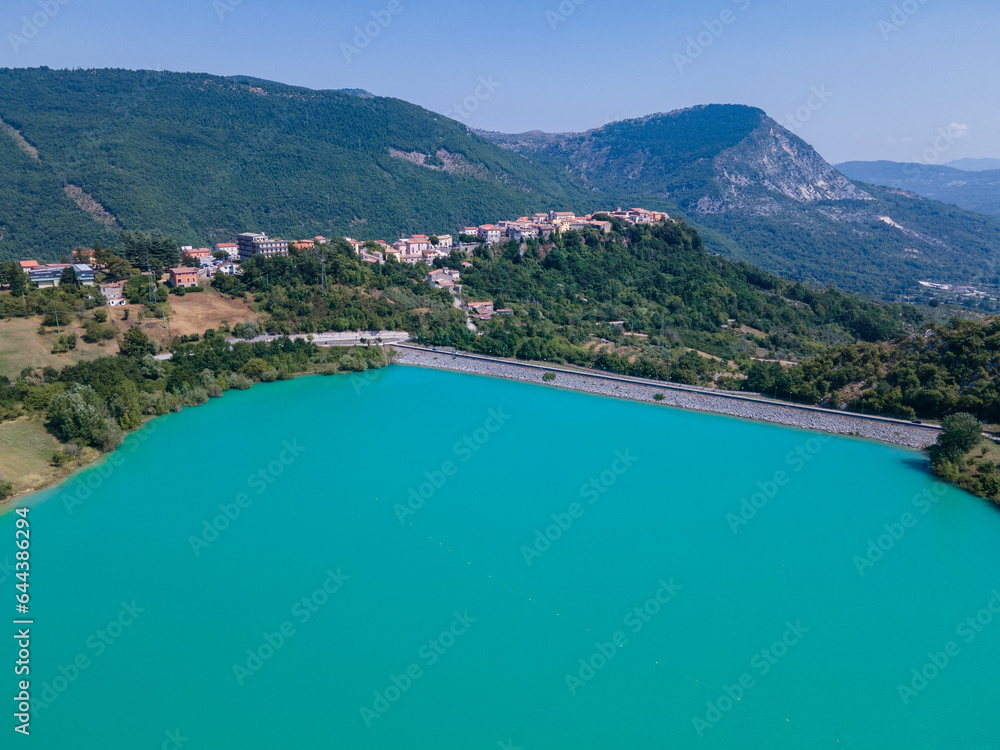 Drone view of the lake with a beach and turquoise water. Camping area on the shore of a mountain lake