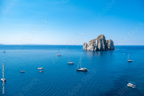 Boats off the coast of the crystal clear sea and rocks. Porto Flavia, Sardegna Italy