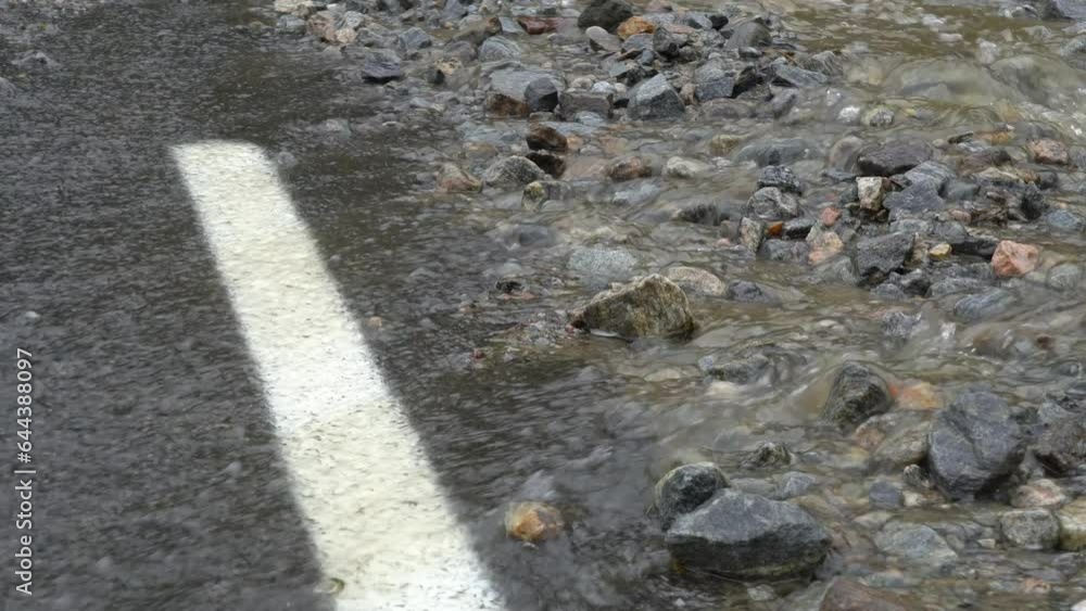 Road overflowed with water during heavy rain - Static closeup detail clip with flooding and climate change concept Road overflowed with water during heavy rain - Static closeup detail clip with flooding and climate change concept