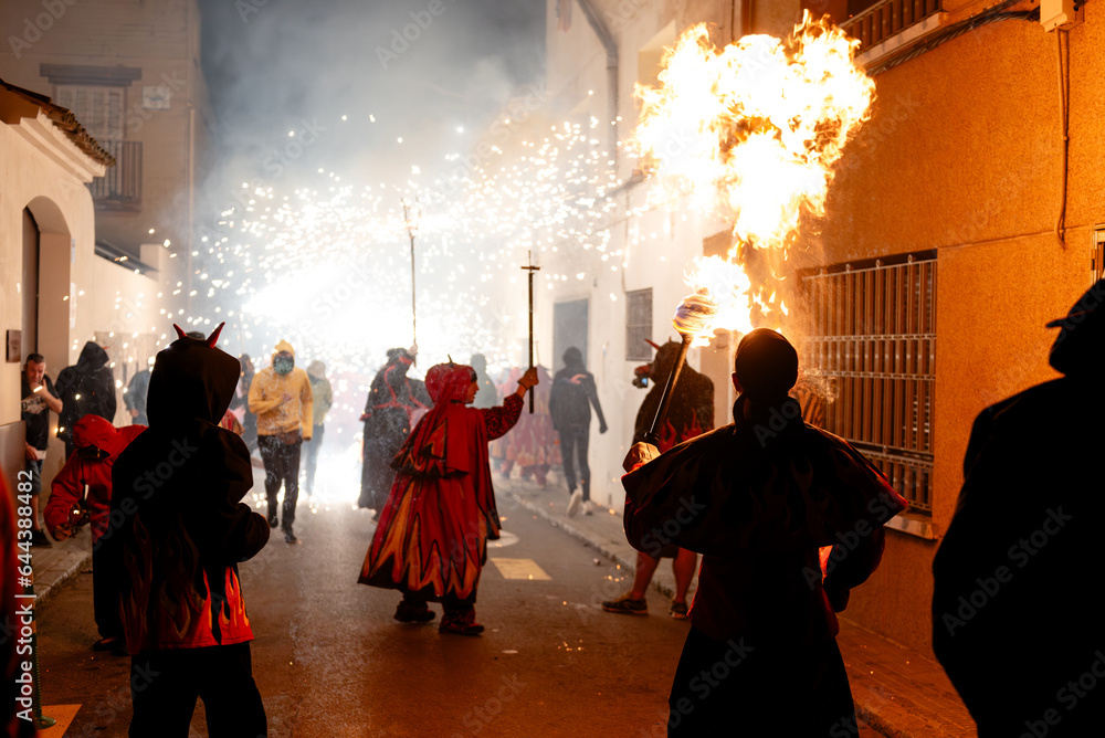 Crowd of people on street with devilish costume with fiery display Crowd of people on street with devilish costume with fiery display