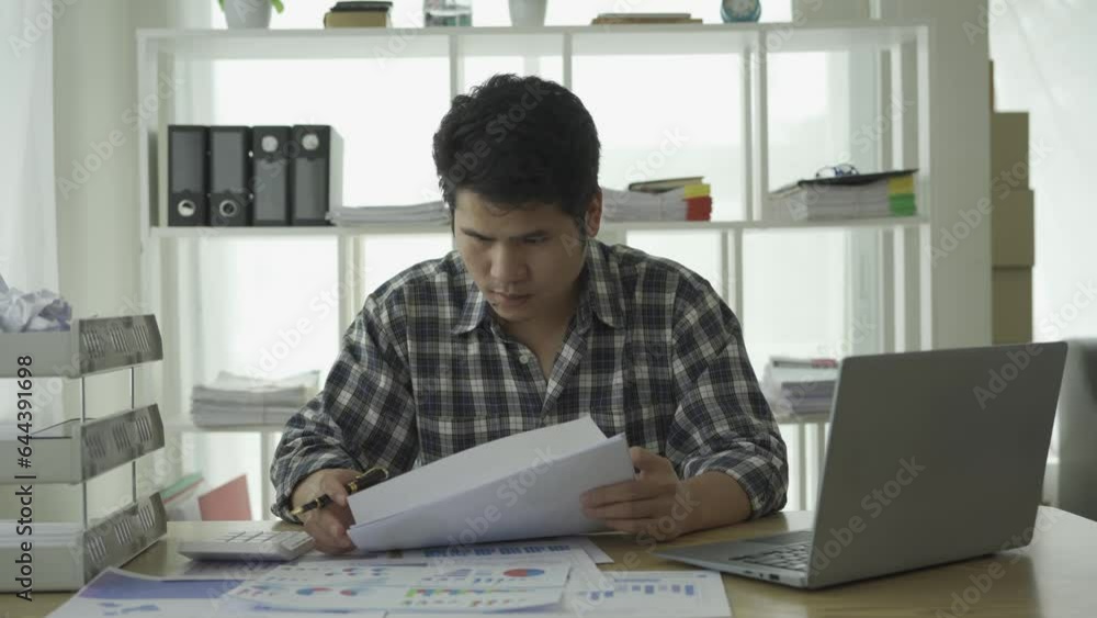 Asian young man excited about successful business Young businessman using computer in office He was energetic and excited about what he was watching on his laptop. Asian young man excited about successful business Young businessman using computer in office He was energetic and excited about what he was watching on his laptop.