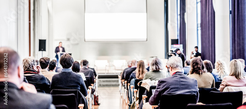 Speaker giving a talk in conference hall at business event. Rear view of unrecognizable people in audience at the conference hall. Business and entrepreneurship concept