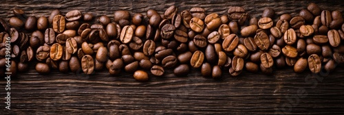 Roasted Coffee beans on wooden background, texture and copy spase, panorama top view. © DenisNata