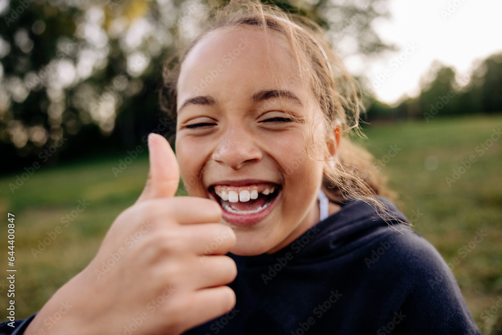 Cheerful girl showing thumbs up gesture Cheerful girl showing thumbs up gesture