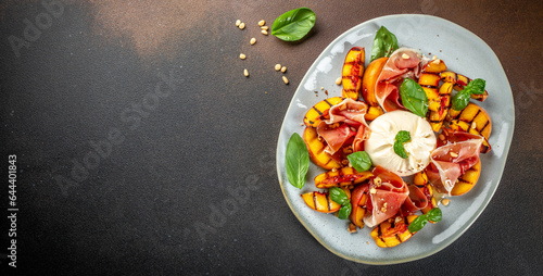 Bild auf Leinwand Grilled peach Caprese salad with mozzarella, prosciutto ham, basil and honey, for wine