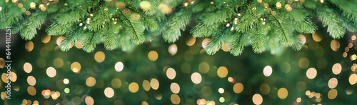 Merry christmas and new year holidays background. Blurred bokeh background with light bulbs and Christmas tree branches. Banner.