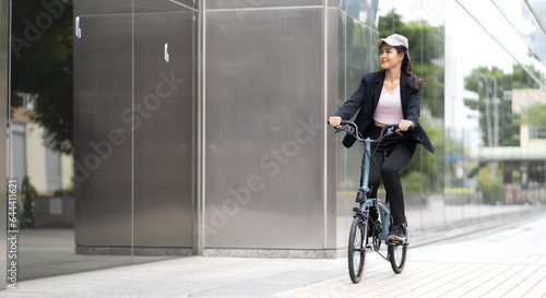 Eco friendly vehicle. 20s businesswoman ride bicycle to work in urban. Cycling has no pollution , alternate commute to global warming. Environmental preservation by riding bicycling. Commuting by bike