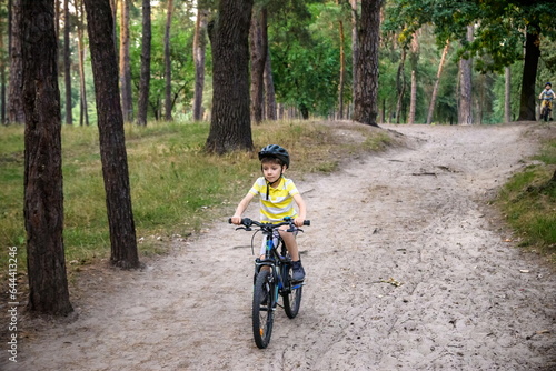 Cyclist Riding down the sandy Hill on the Offroad Trail