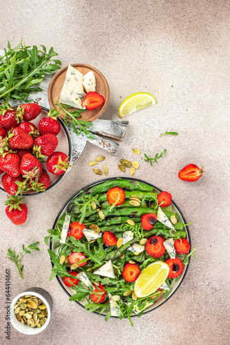 strawberry salad with asparagus, arugula, blue cheese and seeds. Delicious breakfast or snack, Clean eating, dieting, vegan food concept. top view