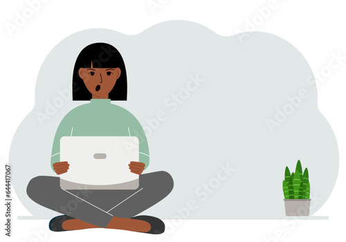 A woman sits cross-legged in his hands holding a laptop. The concept of work, education, reading, watching videos.