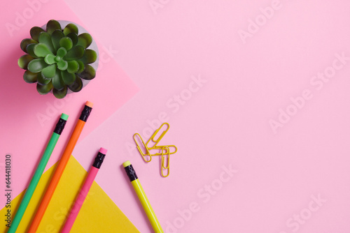Pencils and paper clips on a roh and yellow background. Stationery background.