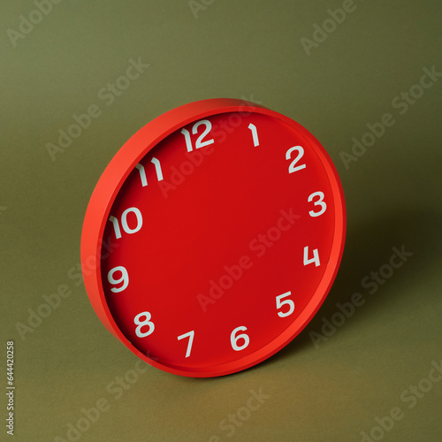 red clock without hands on a green background photo