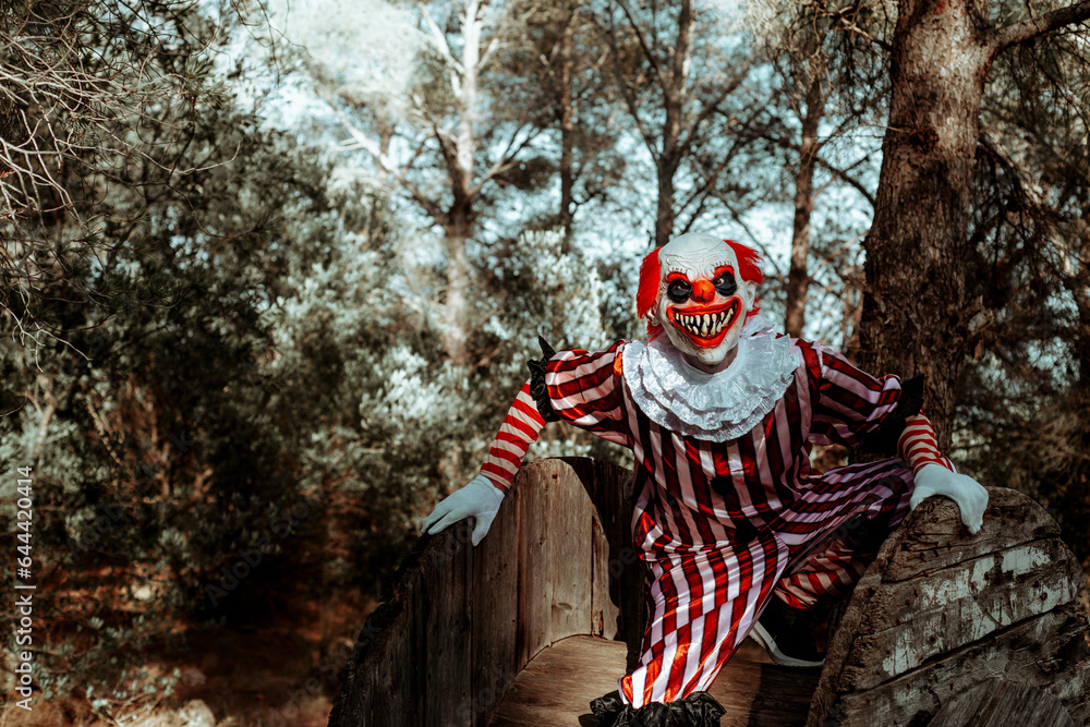 evil clown on a wooden cable reel in the woods
