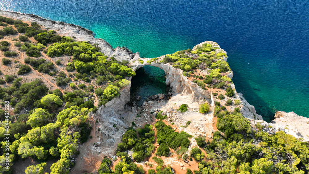 Aerial drone photo of secluded paradise exotic island cove forming a small cave with pebble beach and crystal clear emerald sea surrounded by steep limestone cliffs