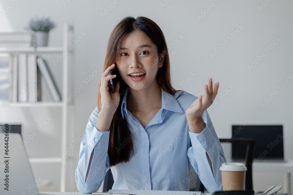 Asian woman talking on the phone, business woman talking on the phone with partner discussing joint venture company, talking on the phone. Communication concept. Asian woman talking on the phone, business woman talking on the phone with partner discussing joint venture company, talking on the phone. Communication concept.