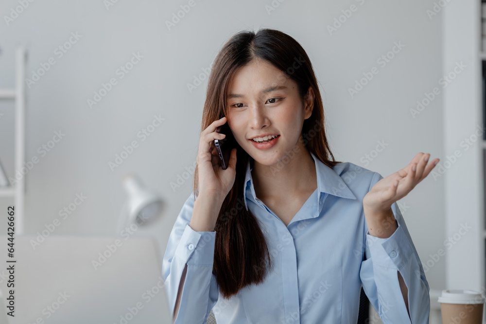Asian woman talking on the phone, business woman talking on the phone with partner discussing joint venture company, talking on the phone. Communication concept. Asian woman talking on the phone, business woman talking on the phone with partner discussing joint venture company, talking on the phone. Communication concept.