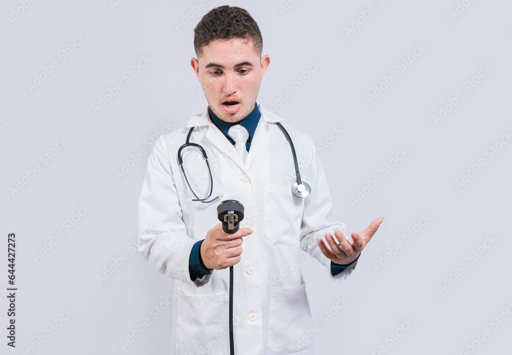 Amazed young doctor with blood pressure monitor isolated. Surprised doctor looking at tensiometer on white background Amazed young doctor with blood pressure monitor isolated. Surprised doctor looking at tensiometer on white background