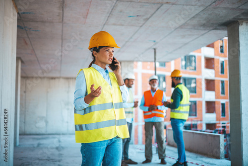 Shot of a young engineer using a smartphone in an industrial place of work. Architect is using mobile phone on construction site. 