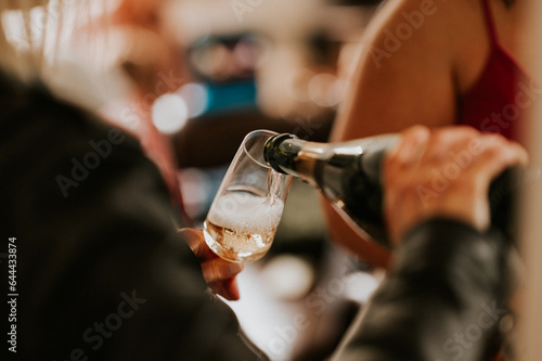 person pouring champagne into glass