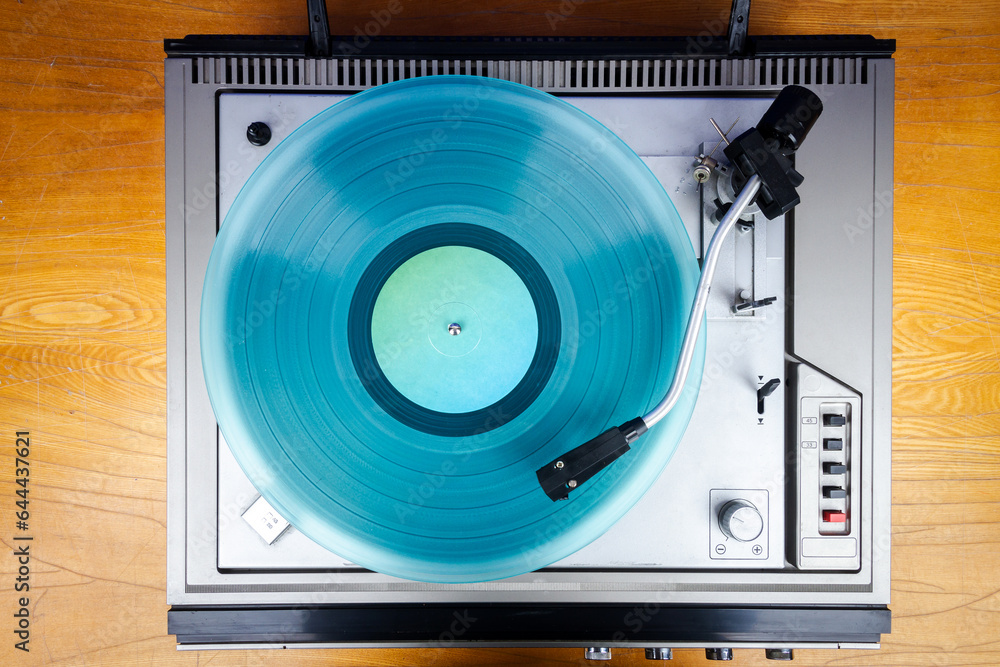 Fototapeta premium Vintage turntable vinyl record player with turquoise vinyl