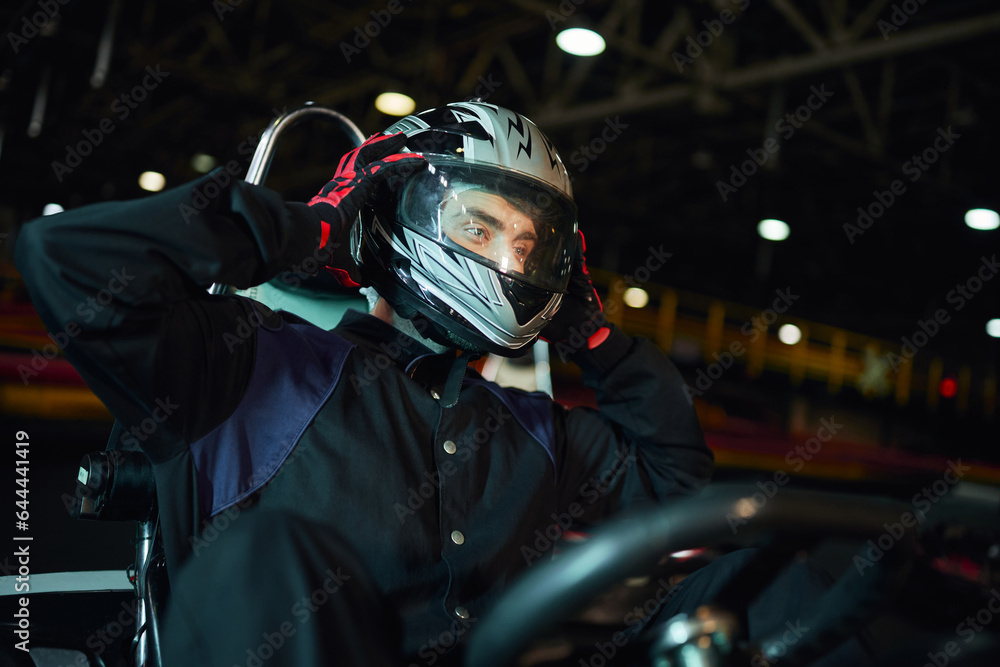 go kart driver taking off helmet after driving on circuit, speed drive and motorsport concept go kart driver taking off helmet after driving on circuit, speed drive and motorsport concept