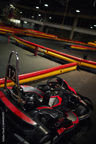 design of red racing car inside of indoor kart circuit, motor race vehicle with number twelve