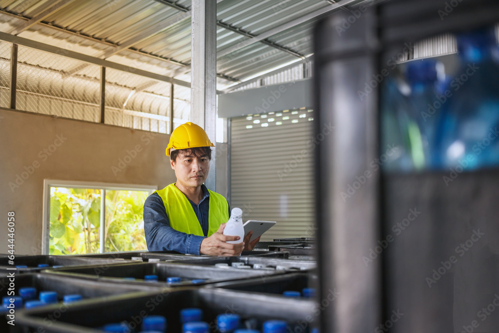 Φωτογραφία In a drink water factory, a tablet computer is being used by a skilled engineer or quality inspector to effectively monitor the process of checking bottled drinking water